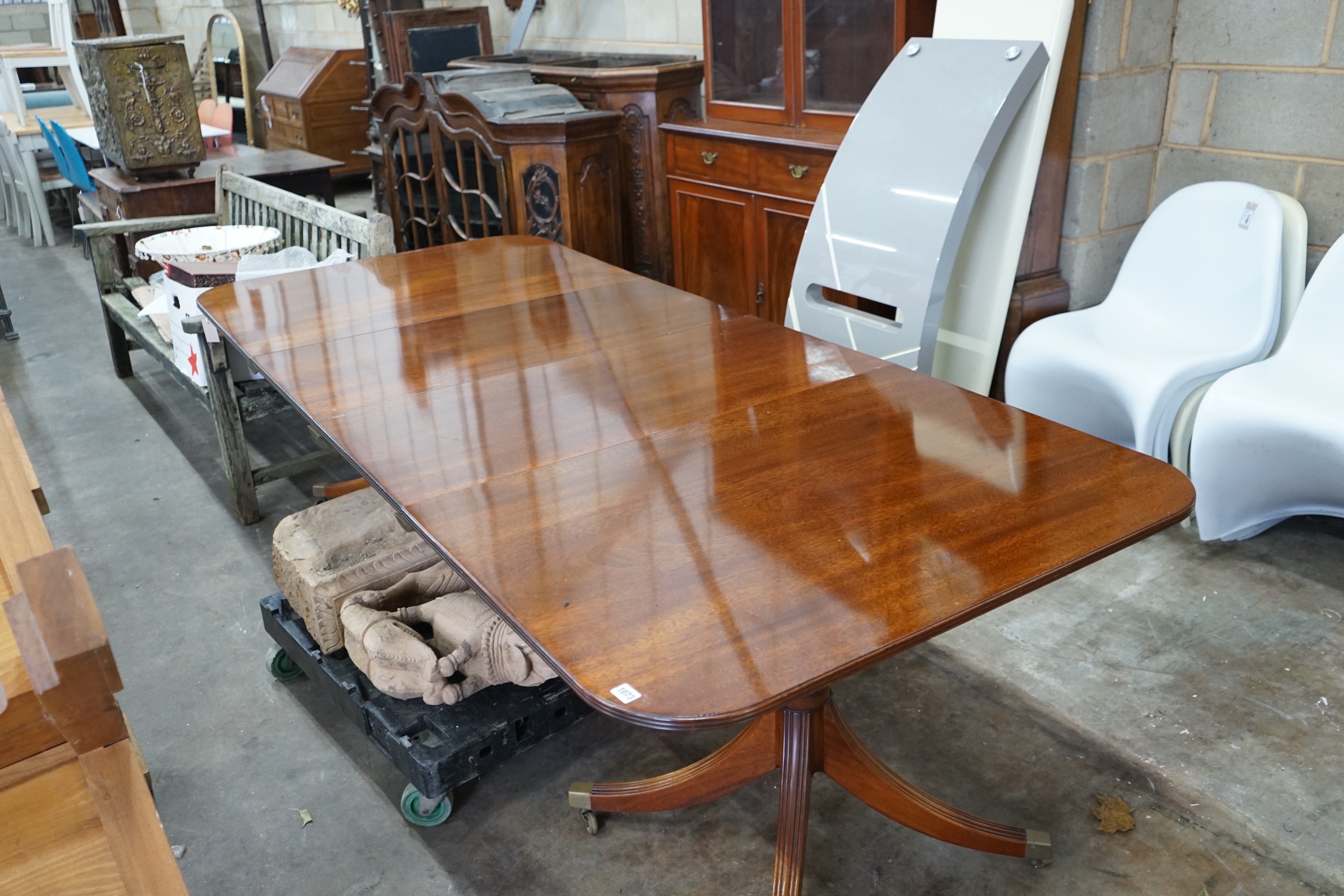 A reproduction Tillman style mahogany twin pillar extending dining table 246cms extended, two spare leaves, width 107cms, height 72cms.